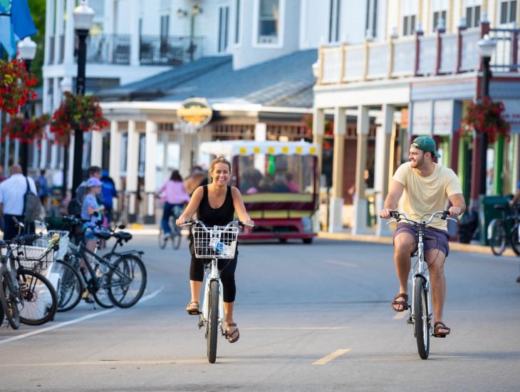 Mackinac Island Couple Biking Down Main Street